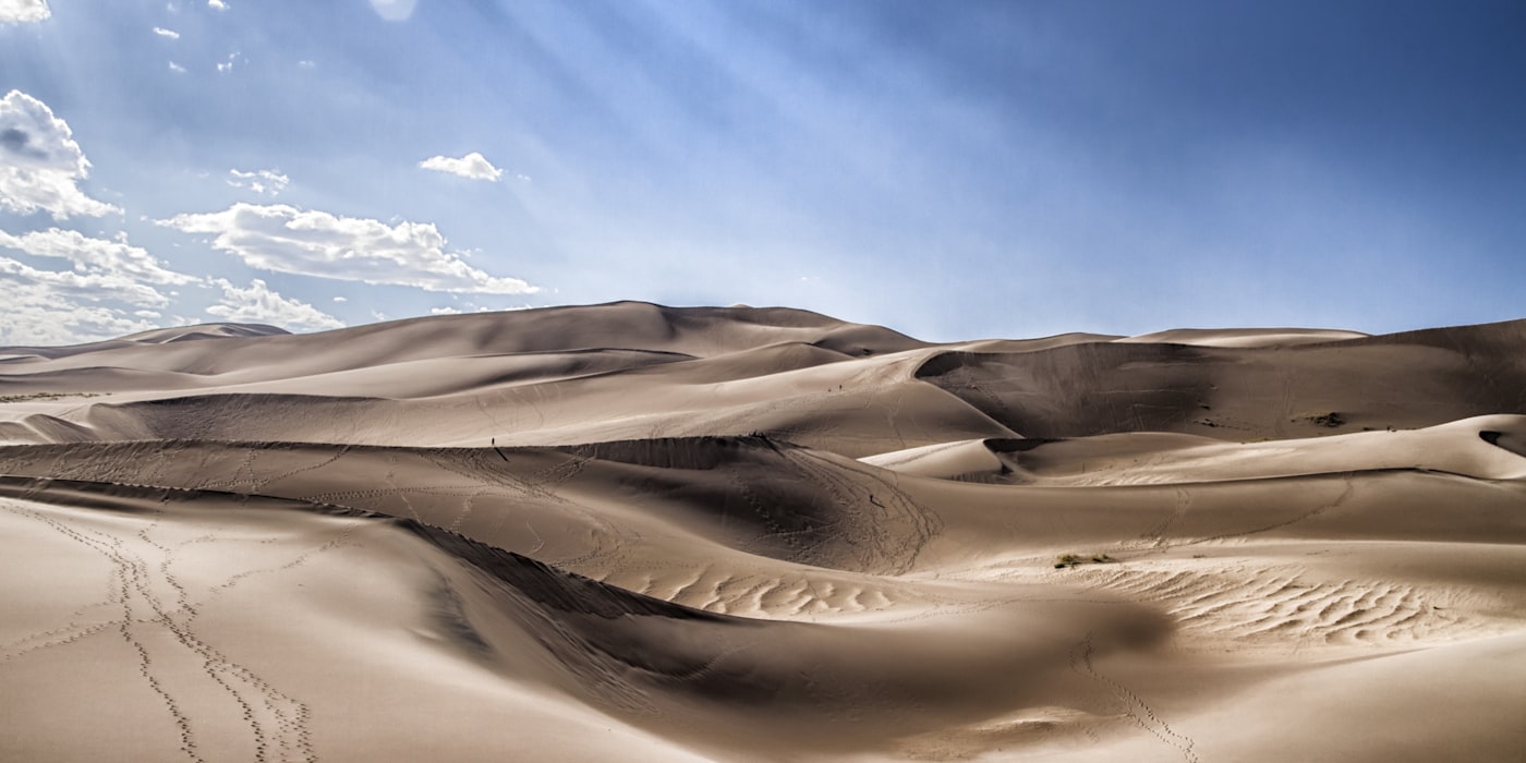 White sand dunes stretching to the horizon under blue sky