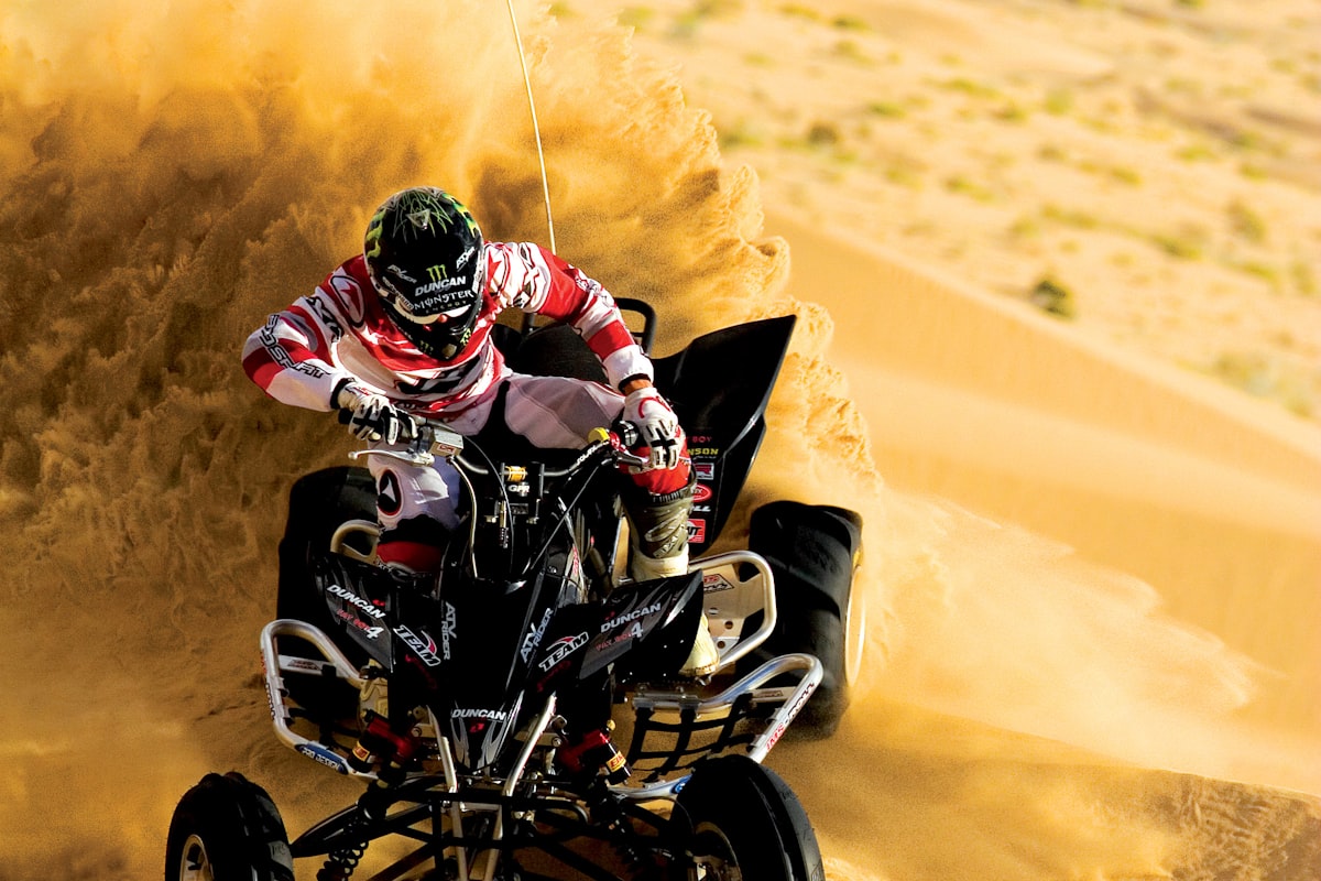 Quad bike racing across sand dunes